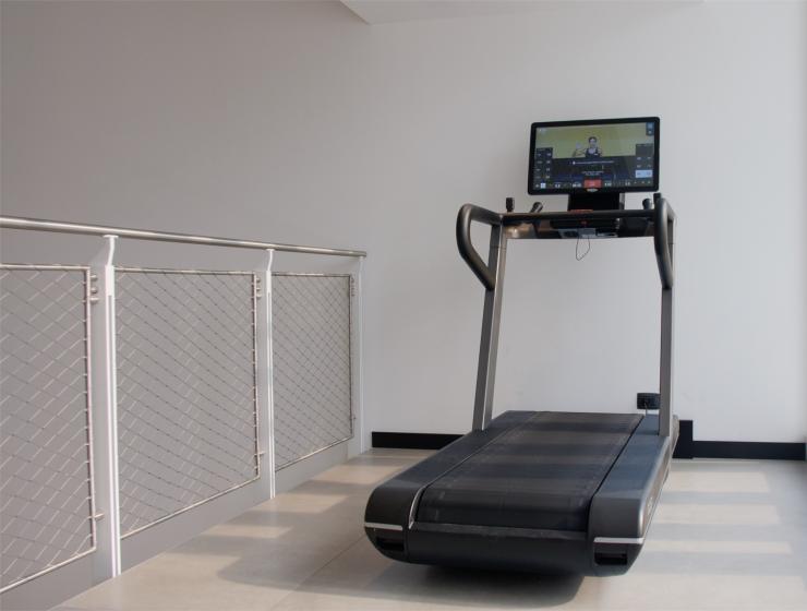 Modern treadmill with screen in a bright room.