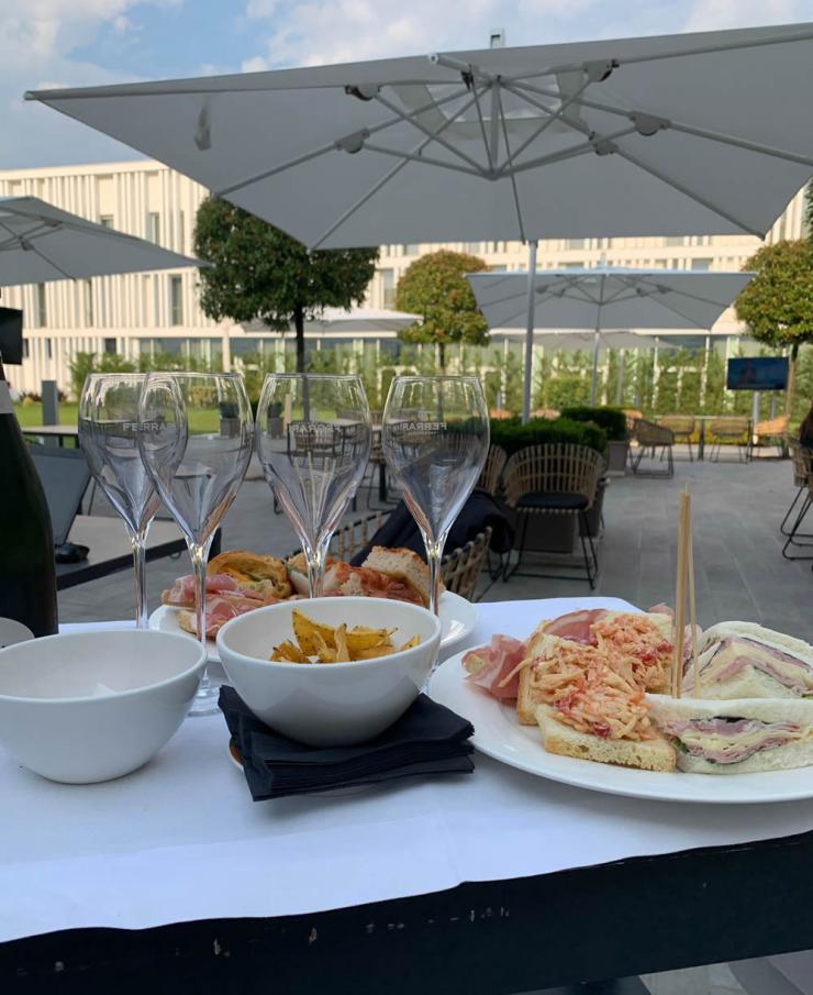 Aperitivo all'aperto con bicchieri di vino e stuzzichini su un tavolo.